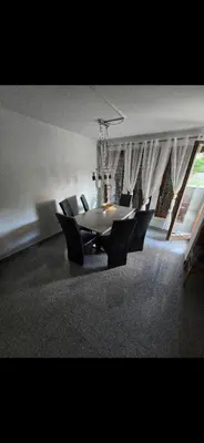 a dining room with a table and black chairs at Stan na Dan Cazin in Ivišovo Greblje