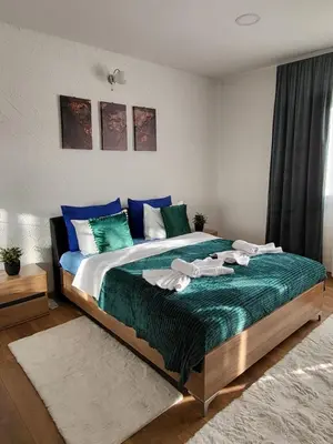 a bedroom with a large bed with towels on it at Apartman A in Livno