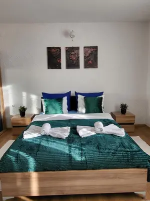 a bedroom with a large bed with towels on it at Apartman A in Livno
