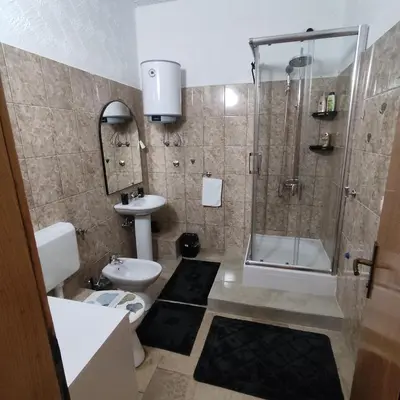 a bathroom with a shower and a toilet and a sink at Apartman A in Livno
