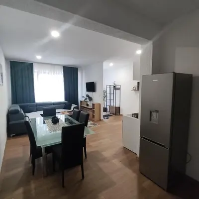 a kitchen and living room with a table and a refrigerator at Apartman A in Livno