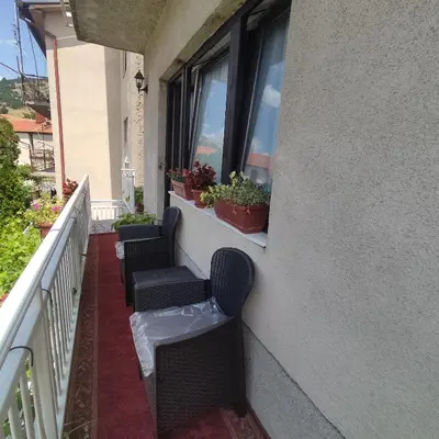 a balcony with three chairs and a window at Apartman A in Livno