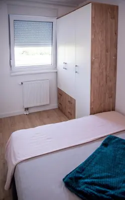 a bedroom with two beds and a window at Apartman Sunset Doboj in Doboj