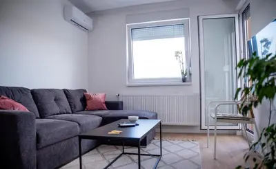 a living room with a couch and a coffee table at Apartman Sunset Doboj in Doboj