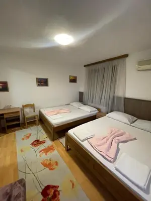 a room with two beds and a table with a desk at Elas in Banja Luka