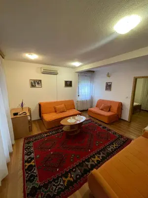 a living room with orange furniture and a red rug at Elas in Banja Luka