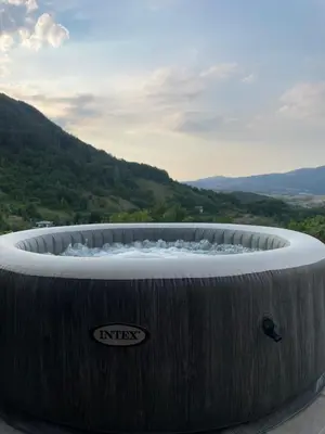a large hot tub with a mountain in the background at Kuća za odmor Ana in Zenica
