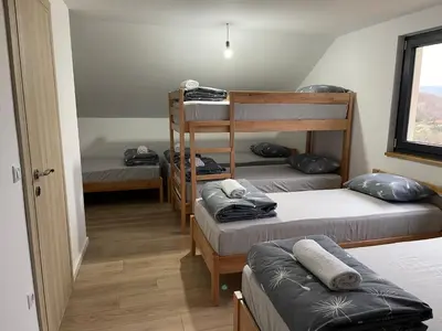 a room with three bunk beds and a window at Kuća za odmor Ana in Zenica