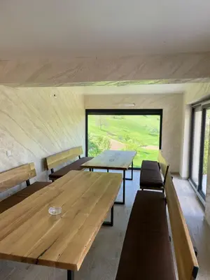 a room with a large wooden table and benches at Kuća za odmor Ana in Zenica