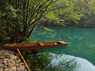 a wooden boat sitting on the side of a lake at UNA Dream in Ivišovo Greblje