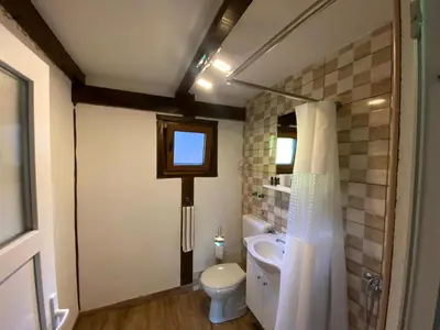 a bathroom with a toilet and a sink and a window at UNA Dream in Ivišovo Greblje