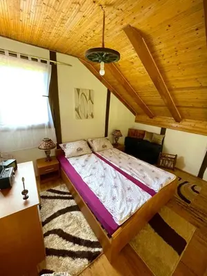a bedroom with a bed and a wooden ceiling at UNA Dream in Ivišovo Greblje