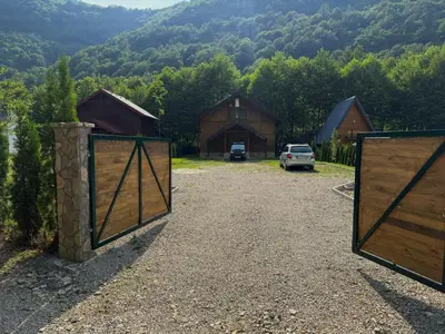 a gate to a barn with a car parked in the driveway at UNA Dream in Ivišovo Greblje