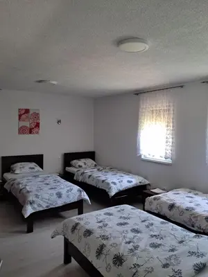 a room with three beds and a window at Al-Batten Vila Bihac in Bare