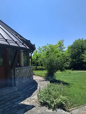a stone building with a stone path next to a field at Al-Batten Vila Bihac in Bare