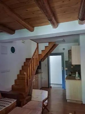 a living room with a wooden staircase in a house at Al-Batten Vila Bihac in Bare