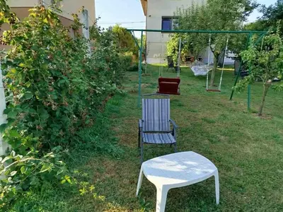 a swing and a chair and a table in a yard at Apartmani LIDER Visoko in Visoko