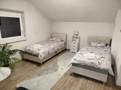 a bedroom with two beds and a window at Apartmani LIDER Visoko in Visoko