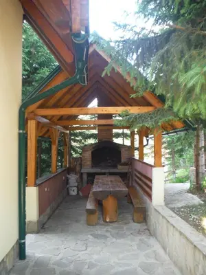 a wooden pavilion with a picnic table in it at Holiday Home Villa Snježina in Vlasic