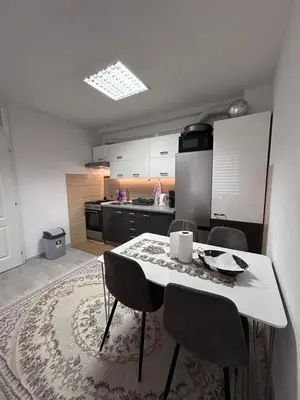 a kitchen with a table and chairs in a room at Apartment Alisa in Vlasic