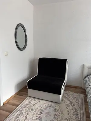 a black and white chair in a room with a mirror at Apartment Alisa in Vlasic