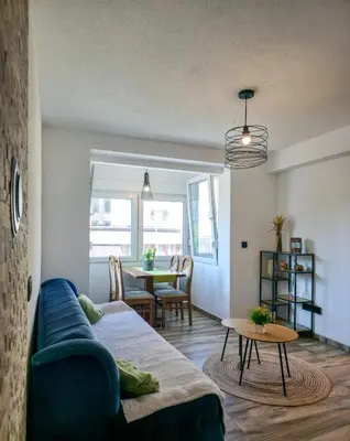 a living room with a blue couch and a table at Urban Nest in Jajce