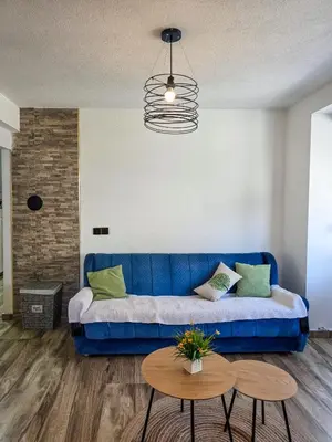 a blue couch in a living room with a table at Urban Nest in Jajce