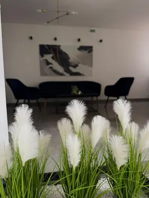 a group of white plants in a room with a piano at Hotel Petar in Kotor-Varoš