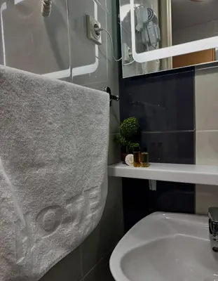 a bathroom with a towel hanging over a sink at Hotel Petar in Kotor-Varoš