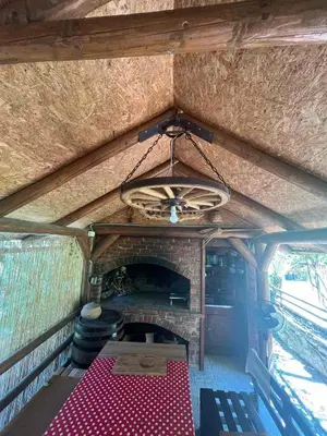 a room with a table and a fireplace in a van at Dunja Cabin - Forest House with Pool in Banja Luka