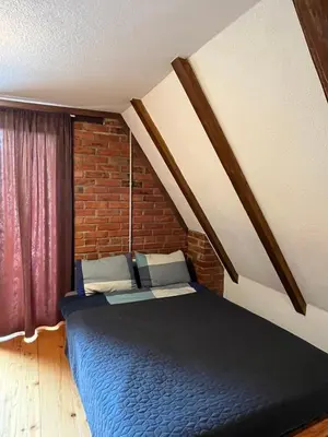 a bedroom with a blue bed and a brick wall at Dunja Cabin - Forest House with Pool in Banja Luka