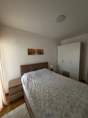 a bedroom with a bed and a painting on the wall at Lux Apartman Banjaluka in Banja Luka