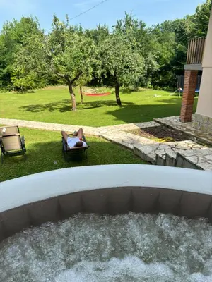 a person laying in a chair in a backyard with a hot tub at Rancbl in Banja Luka