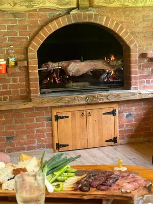 a turkey is cooking in a brick oven at Rancbl in Banja Luka