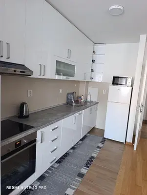 a kitchen with white cabinets and a white refrigerator at Apartman Phoenix in Banja Luka