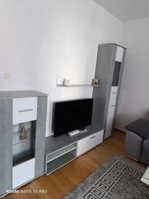 a living room with a entertainment center with a flat screen tv at Apartman Phoenix in Banja Luka