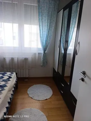 a bedroom with a bed and a window and a rug at Apartman Phoenix in Banja Luka