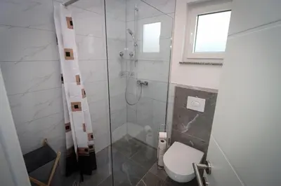 a bathroom with a toilet and a glass shower at Kuća za odmor Ana in Prozor