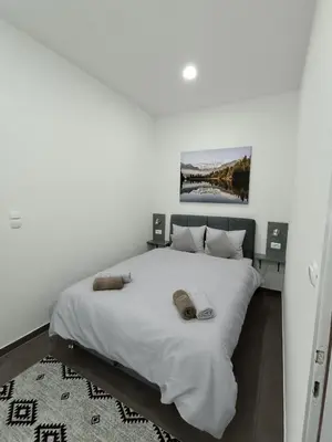 a bedroom with a white bed with two pillows on it at Una Festa Apartment in Bihać