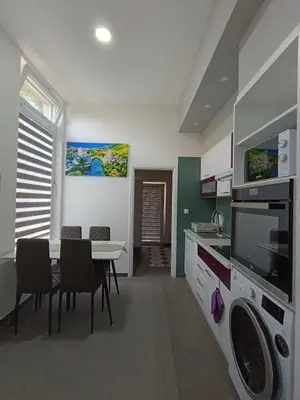 a kitchen with a table and a dining room at Una Festa Apartment in Bihać