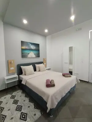 a bedroom with two beds and a painting on the wall at Una Festa Apartment in Bihać