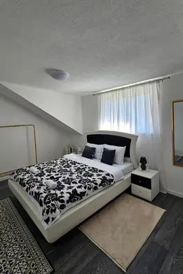 a bedroom with a black and white bed and a window at Apartments Una Roots in Orašac