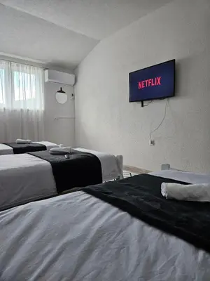 a hotel room with two beds and a tv on the wall at Apartments Una Roots in Orašac
