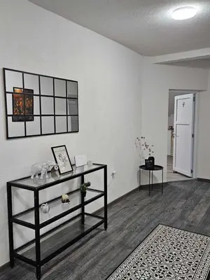 an empty living room with a table and a shelf at Apartments Una Roots in Orašac