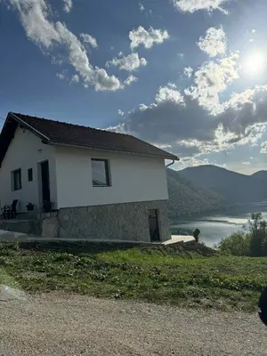 a white house with a view of a river at Cottage Arinda in Jajce