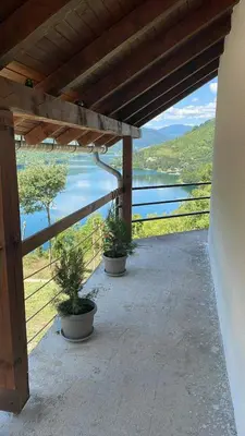 a porch with two potted plants and a view of a lake at Cottage Arinda in Jajce