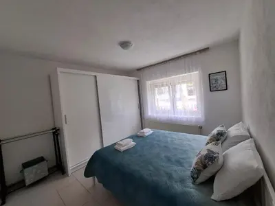 a bedroom with a blue bed with two towels on it at Apartman Mint in Bihać