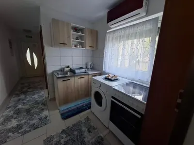 a kitchen with a sink and a washing machine at Apartman Mint in Bihać