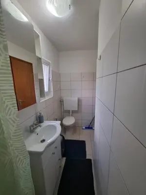 a white bathroom with a sink and a toilet at Apartman Mint in Bihać