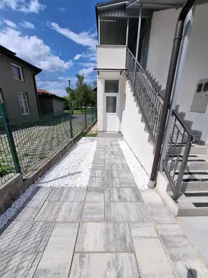 a walkway outside of a white building at Apartman Mint in Bihać